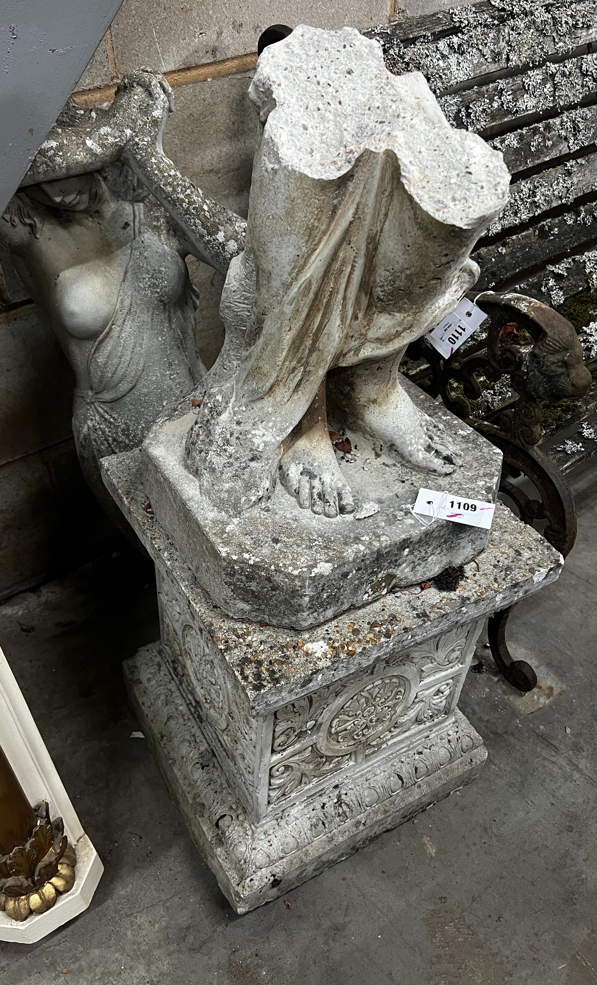 A reconstituted stone garden figure of a lady, wearing a diaphanous gown, on a square plinth, height 162cm (in need of restoration)